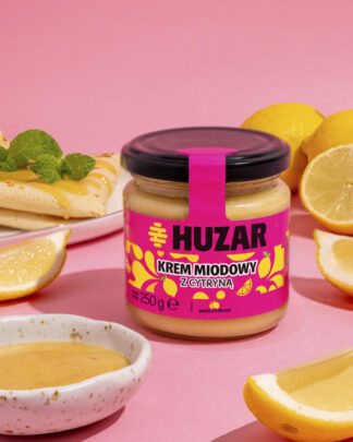 Krem miodowy z cytryną HUZAR 250 g w otoczeniu świeżych cytryn i naleśników.